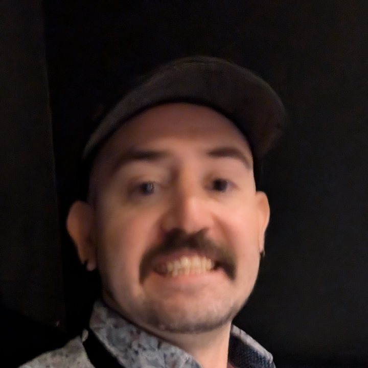 Alan, grinning, in a black cap